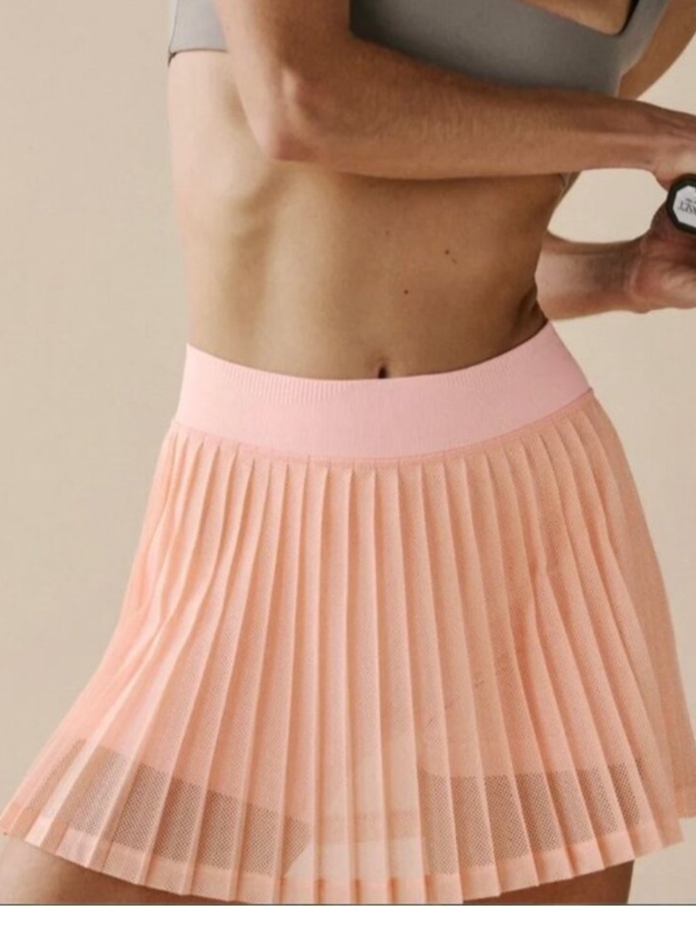 Free People Movement Rally Ruffle Mini Skirt in a pastel peach color.